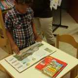 Un bambino mentre maneggia un libro dedicato ai dinosauri